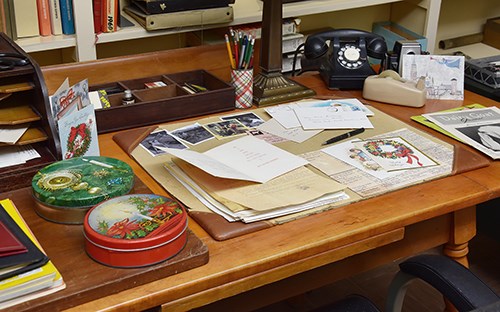 Image of a desk strewn with holiday cards and cookie tins