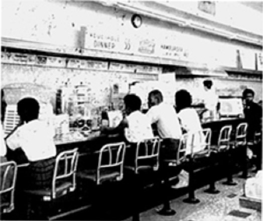 Young African American students sitting at Woolworth's counter during a sit-in civil rights demonstration.