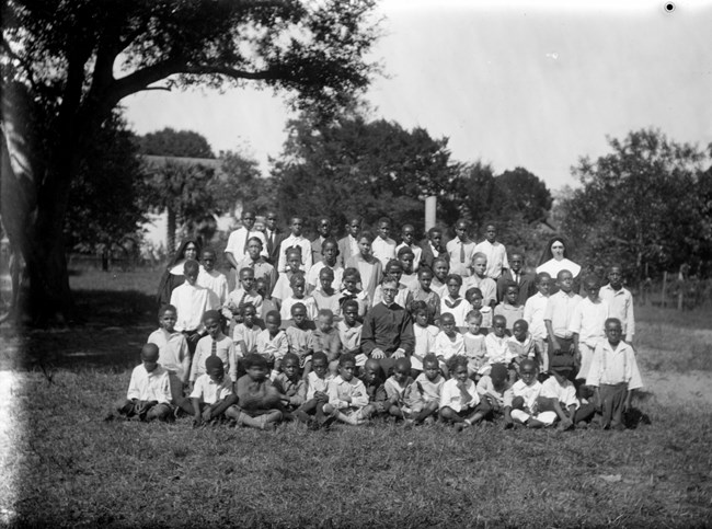 St. Benedict Catholic School class photograph of African American students with the white nuns and priest.