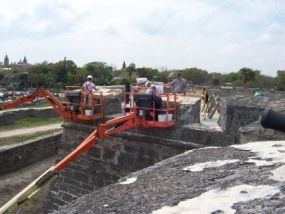 Workers from the NPS Historic Preservation Training Center work on the top of the Castillos walls.