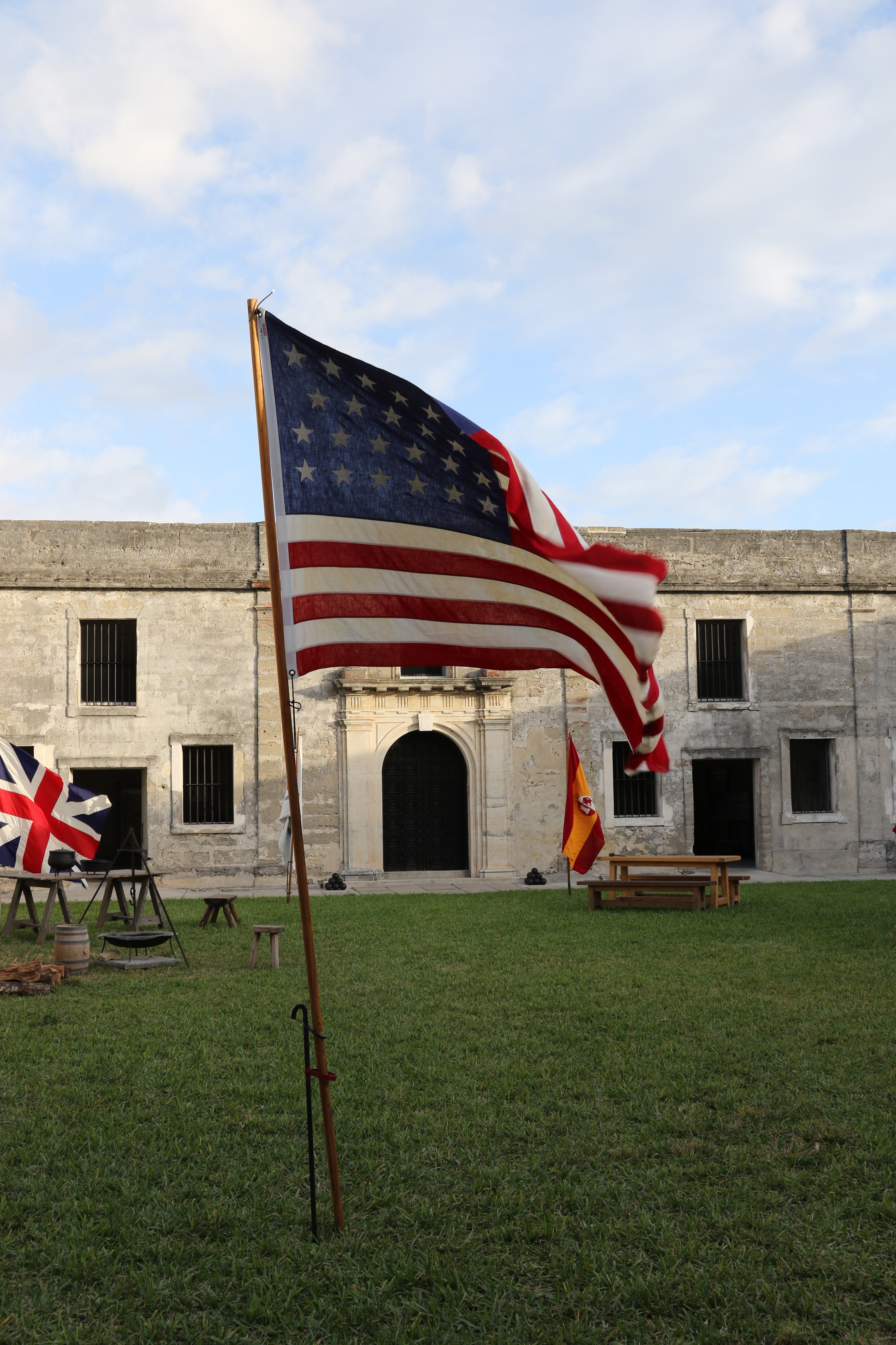 Castillo de San Marcos NM Veterans Day historical american flag in the foreground with the british and spanish flags behind in the courtyard of the old spanish fort