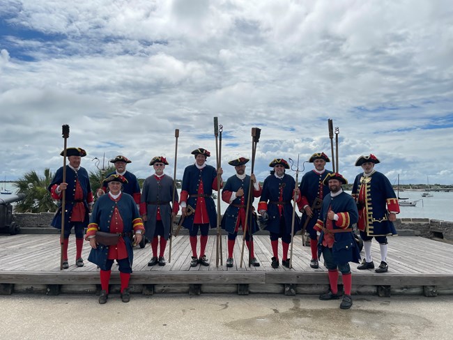 Group of people dressed in blue colonial uniforms