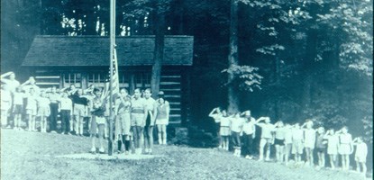 Historic photo of Girl Scouts raising American flag at Camp Misty Mount