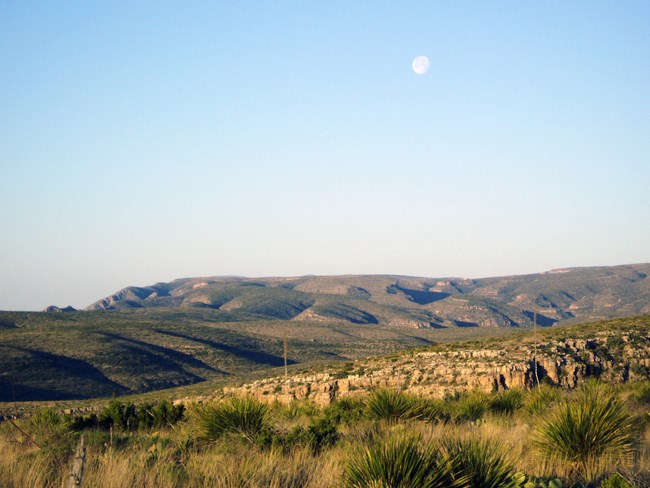 View of the mountains from the trail with the moon overhead