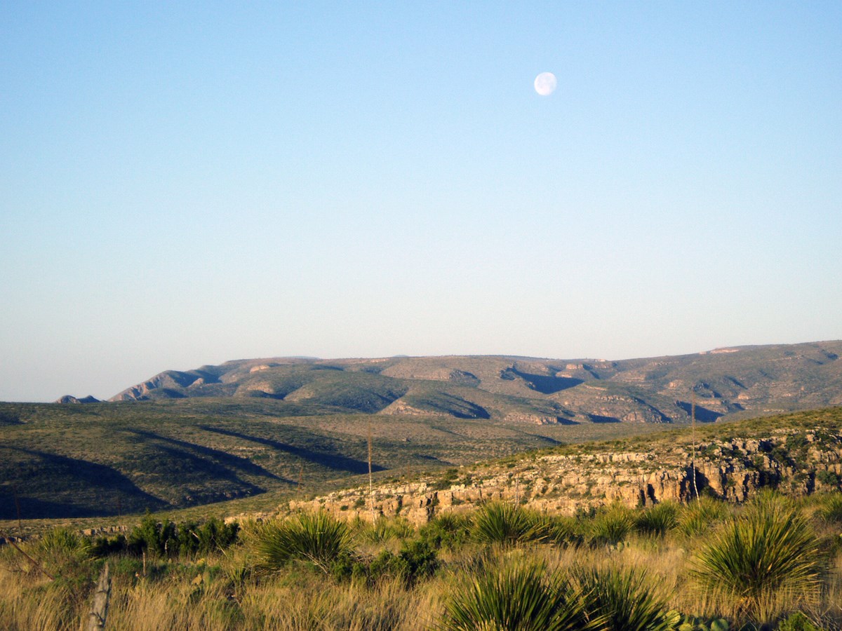 View of the mountains from the trail with the moon overhead