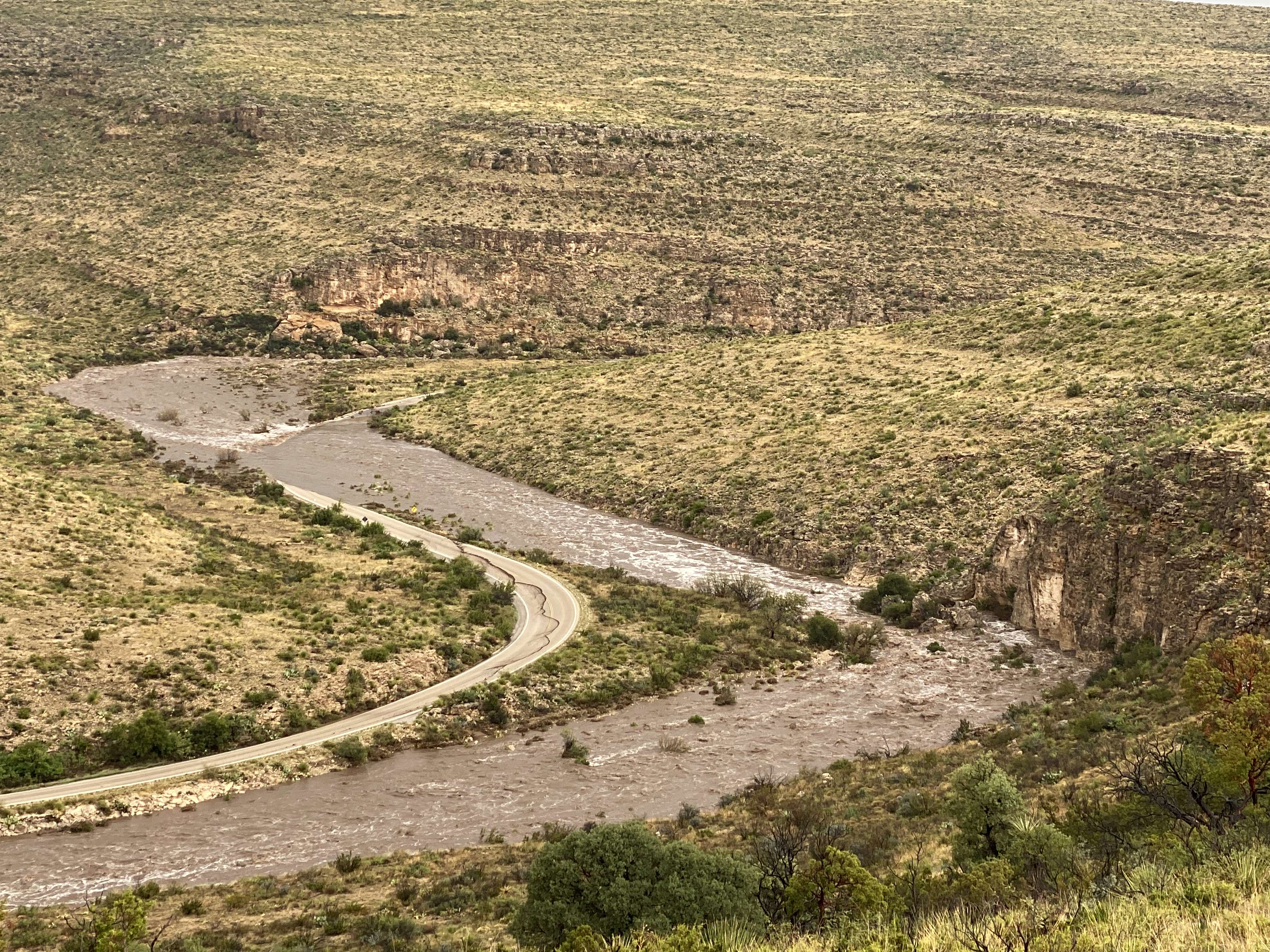 Photo of flooding in Walnut Canyon flowing over the main park road.