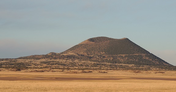 Evening light shines on Capulin Volcano across the prairie