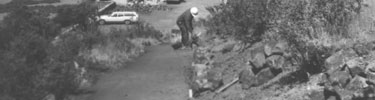 black and white photograph of worker in hardhat building rim trail