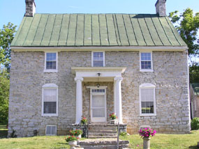 A small, Colonial American two-story stone house. A small, Colonial American two-story stone house.