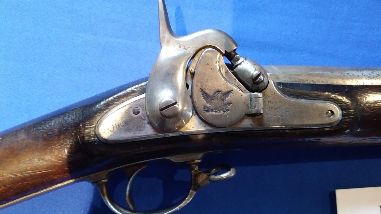 A lock of an antique rifle seen close up.