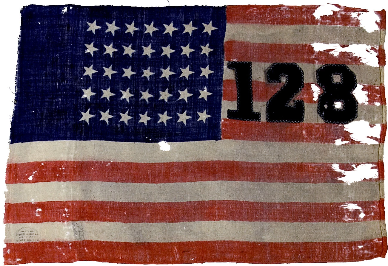 128th NY Camp Flag A tattered antique US flag has 35 stars and 128 embroidered on it.