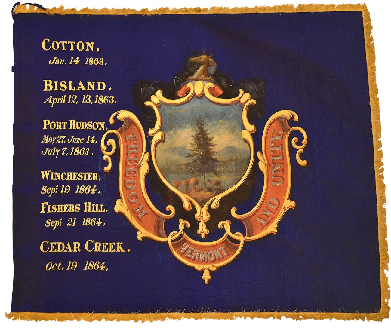 A blue flag with gold fringe has a state crest with a list of battles.