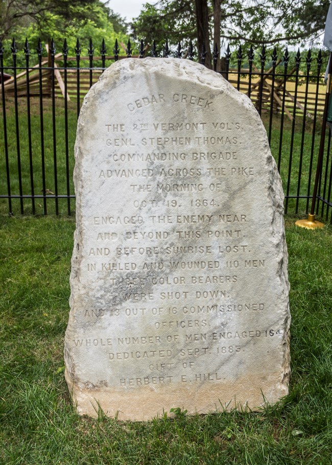 A marble monument in a fenced enclosure commemorates Vermont soldiers who fought a battle in the Civil War.