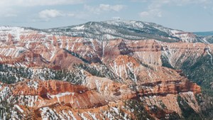 A view of a landscape of red cliffs with minimal snowpack.
