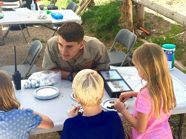 Dissecting Owl Pellets Kids with park employee dissecting owl pellets.
