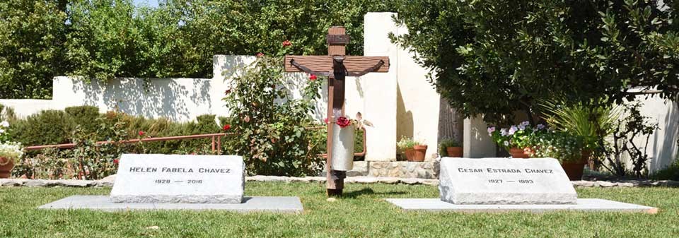 The graves of Cesar and Helen Chavez surrounded by green grass The graves of Cesar and Helen Chavez surrounded by green grass