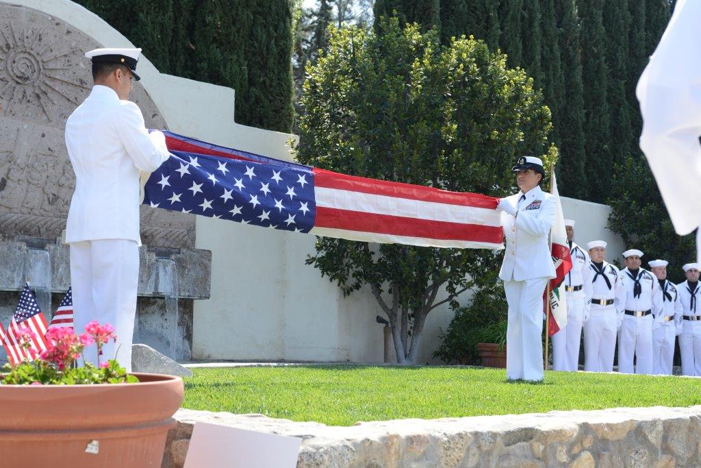 Sailors fold flag during military honors