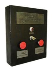 black box with a plaque, small light, key switch, and two large red buttons