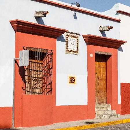 White stucco building front with orange framed window and door