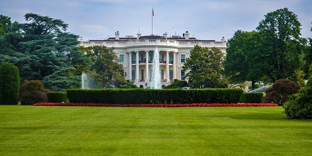 Landscape view of the White House from across a lawn, featuring the semicircular south portico