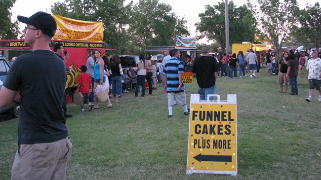 Food and Beverage Vendors many people on a lawn in front of a line of food trucks