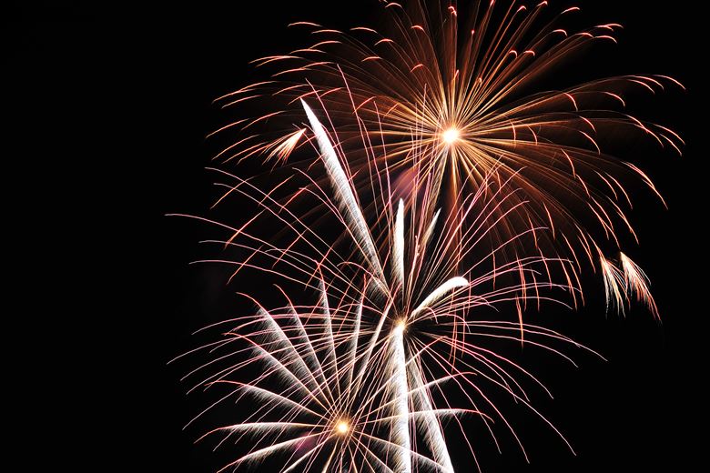 white and red starbursts of fireworks against a dark sky