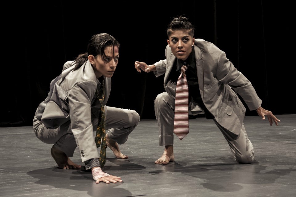 XIPE Colectivo Escénico performs Aquerón: el Río de la Tragedia two actresses costumed as men crouch onstage