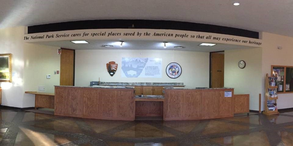long reception counter with overhead inscription: "The National Park Service cares for special places saved by the American people so that all may experience our heritage."