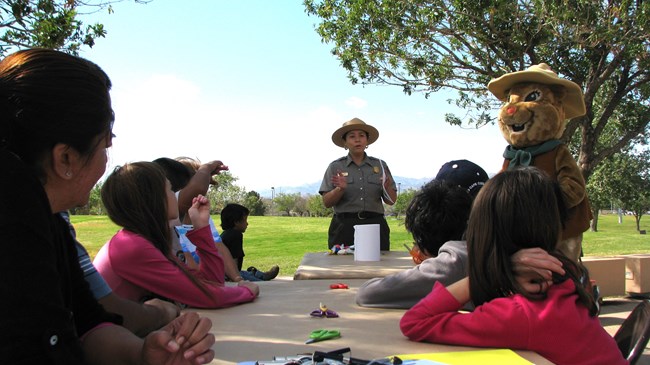 A park ranger speaks to a group of young people