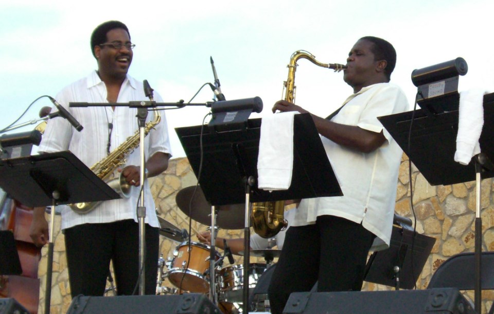 Two saxophone players on an outdoor stage Two saxophone players on an outdoor stage