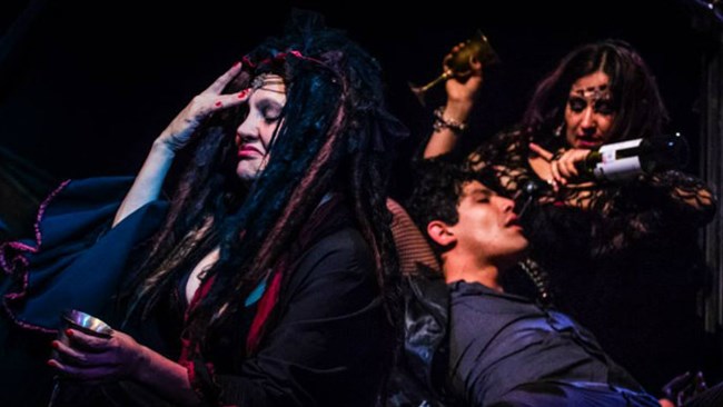 Close-up of three actors in dark costumes performing in a play. Close-up of three actors in dark costumes performing in a play.