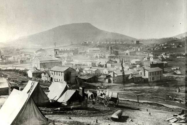 Chattanooga as it appeared in 1864 with dirt streets and Lookout Mountain looming in the background.