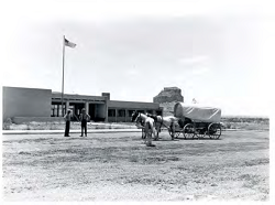 A horse and carriage outside the park's visitor center with two park rangers