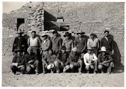 A group posing in front of a ruins wall.