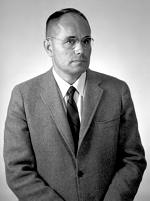 Malde taking a formal photo wearing a suit.