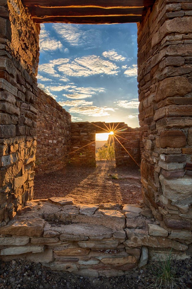 The sun shining through an opening of two doorways of an ancient great kiva.