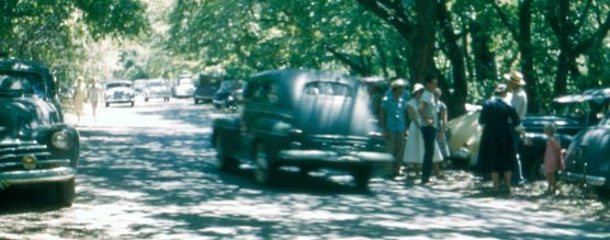 1940s cars and visitors along a crowded roadway