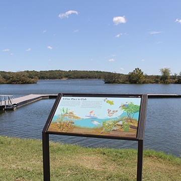 a sign with illustrations and text near a boat dock