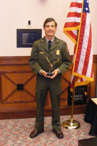 Park ranger in uniform holding an award