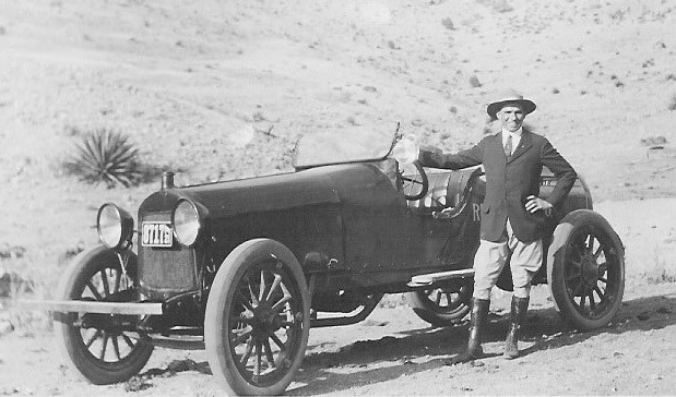 Black and white photo of man and old-fashioned car.