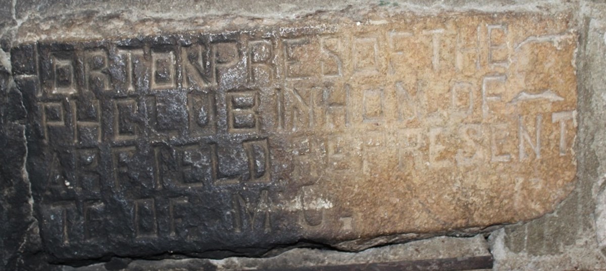 Brown stone carved with partial name.