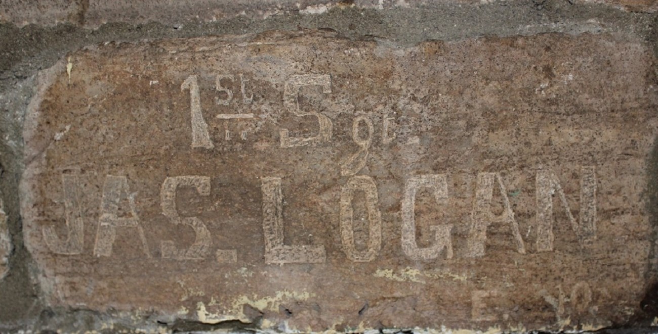 Reddish brown stone carved with man's name, "1st Sergeant James Logan."