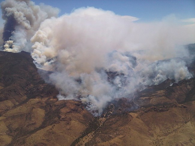 smoke billowing up from rugged mountains