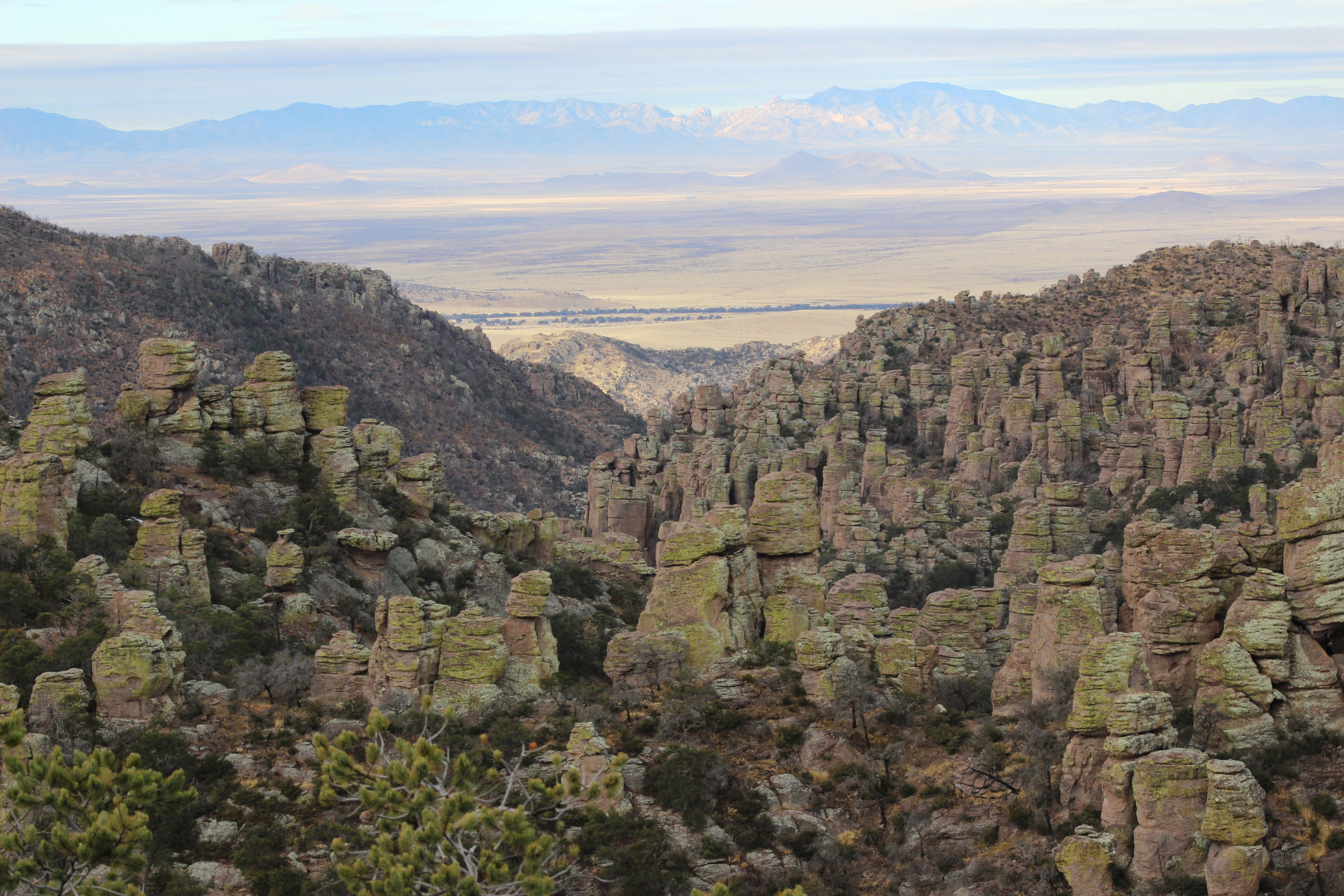 Rock formations with valley and mountain view in the distance.