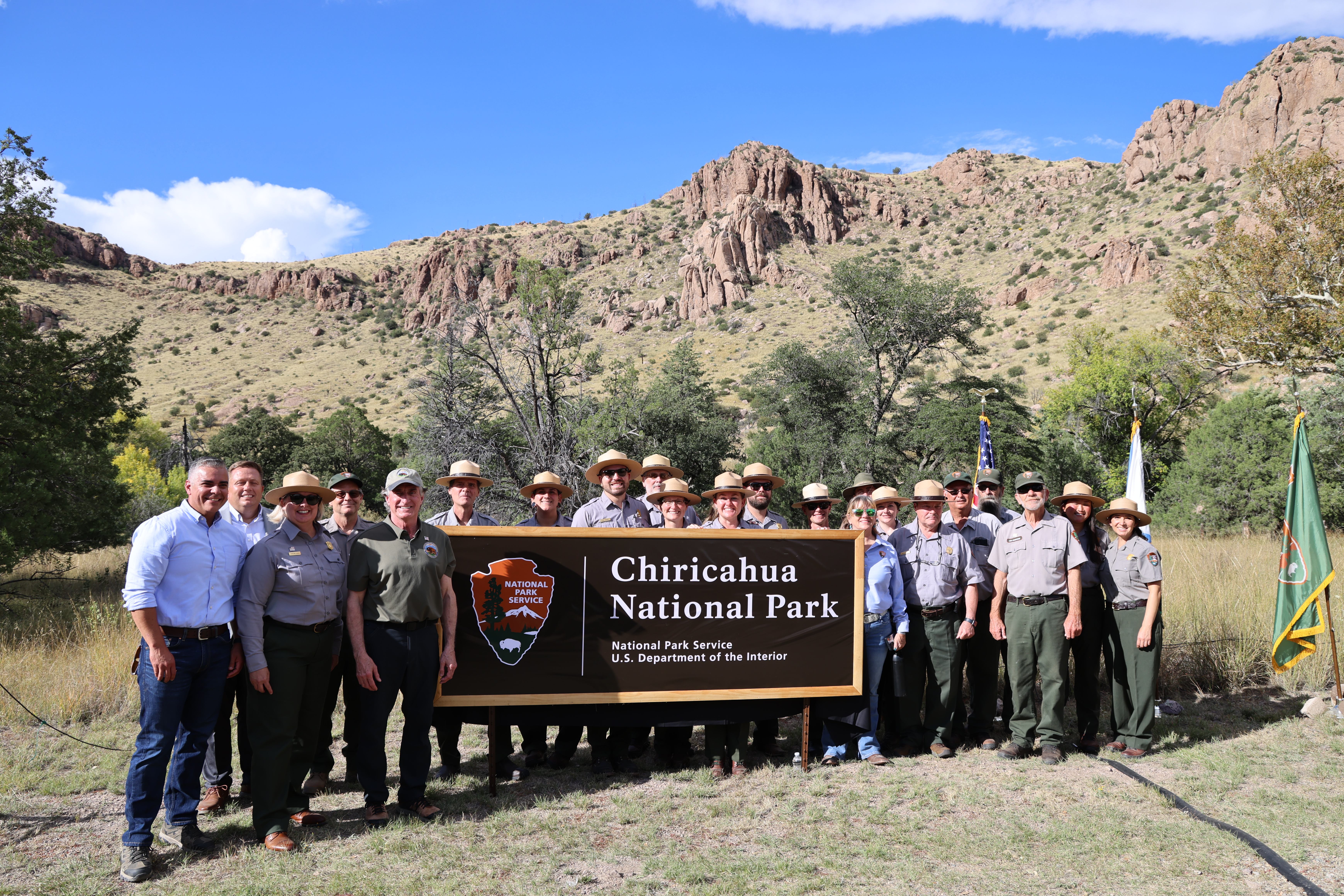 Image with rangers and park staff behind sign that says Chiricahua National Park.