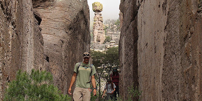 A hiker makes his way through a rock canyon A hiker makes his way through a rock canyon