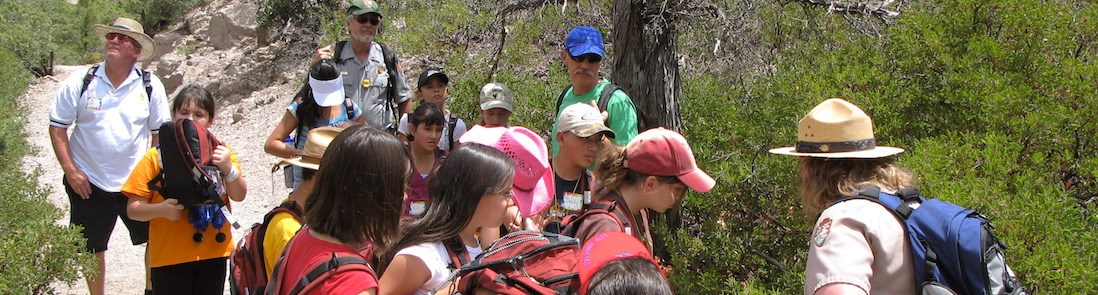 A ranger teaches a group on the trail