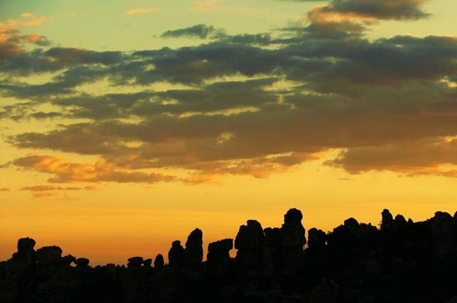 Sunset behind skyline of balancing rocks.