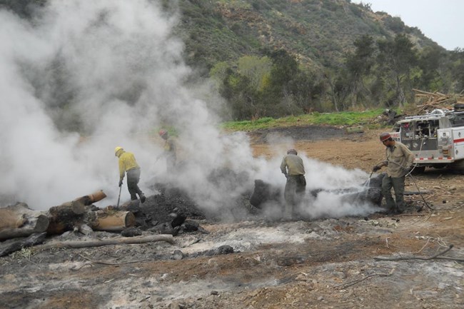 Firefighters surrounded by smoke.