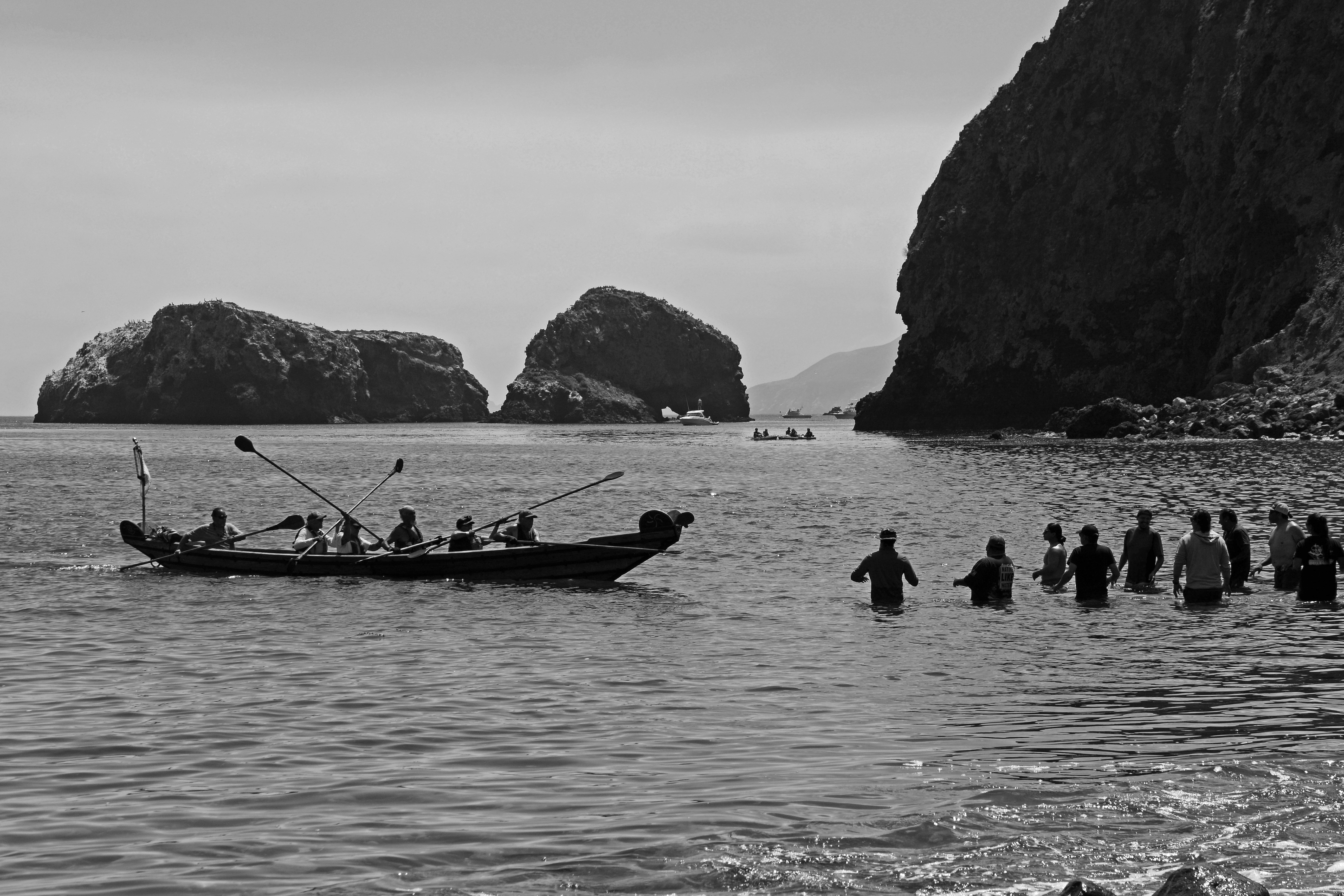 traditional canoe like watercraft being paddled into beach